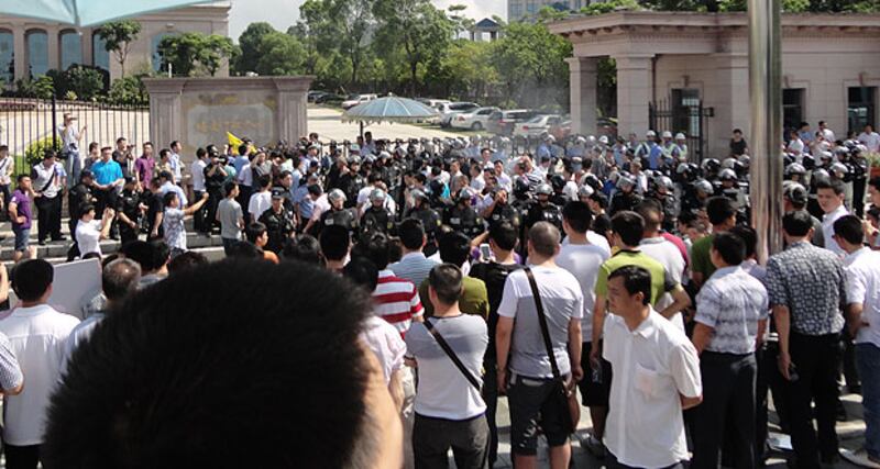 2013年7月29日，塘廈鎮政府派出大批的警察，阻止示威者接近辦公大樓。（死者家屬提供）