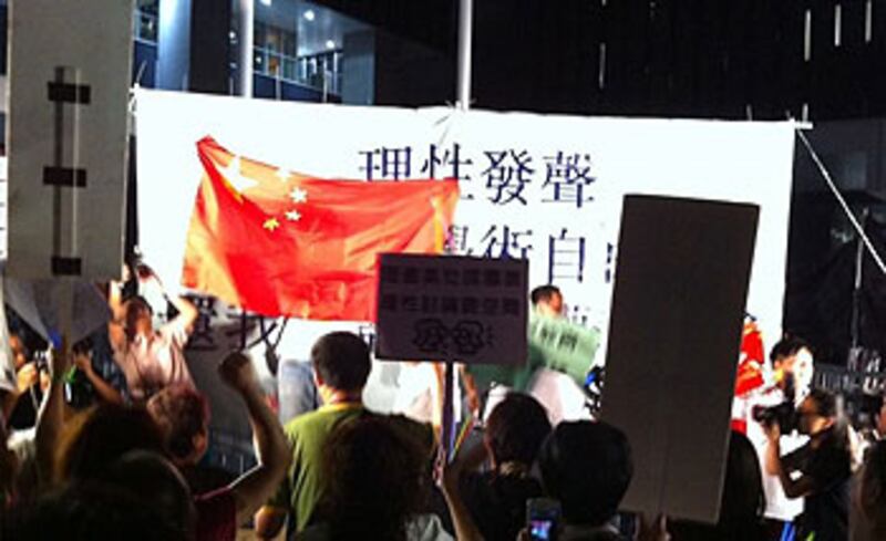 2012年10月17日,支持推行國教科晚會的人士,於台前高舉國旗。(粵語部記者林靜攝)