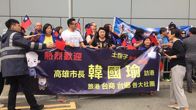 韩国瑜3月22日早上抵达香港机场时,有支持者手持标语和青天白日满地红旗欢迎。(现场人士提供)