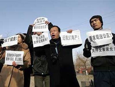 图片：1月22日，三鹿奶粉受害儿童家长在石家庄中级人民法院门外抗议（法新社）