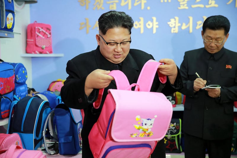 김정은 북한 국무위원장(왼쪽)이 2017년 1월,새로 지어진 평양 가방 공장 시찰하고 있다.