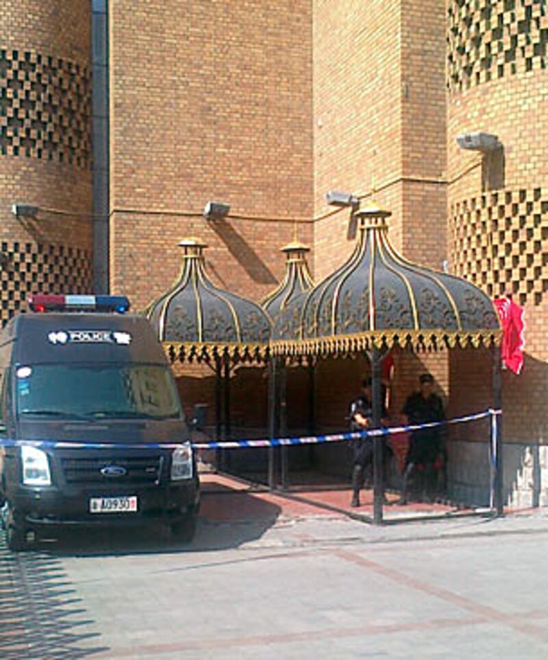 一部警車停在大巴扎外戒備,兩名特警在旁駐守。(照片由居民提供、攝於2012年7月5日)