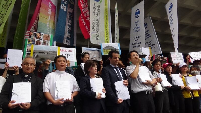 受害越南人和声援民团手捧诉状书。（记者夏小华摄）