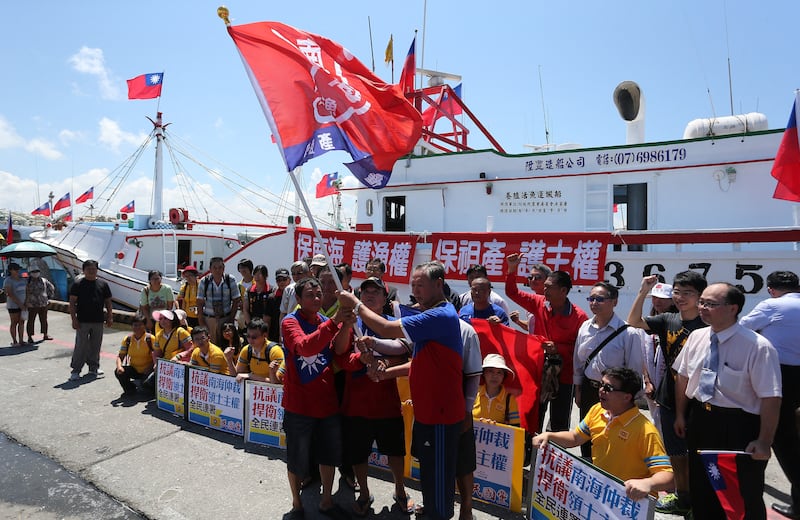 Taiwanese fishermen display flags and placards before departing to Taiping island, part of the disputed Spratly Islands chain in the South China Sea, at a fishing harbour in southern Pingtung on July 20, 2016.
