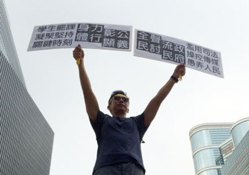 A pro-democracy protester holds anti-government placards demanding justice for the people in Hong Kong, Oct. 2, 2014. Credit: RFA