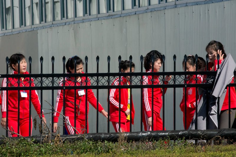 In this Sept. 30, 2017, photo, North Korean workers gather after lunch at the Hong Chao Zhi Yi garment factory in Hunchun, in northeastern China's Jilin province.