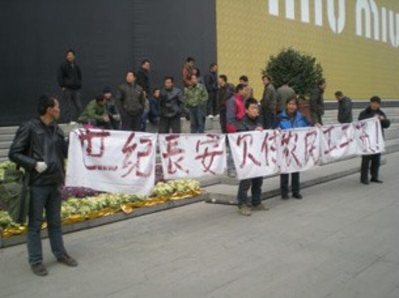 图片： 各地农民工在西安市内拉横幅讨薪。 （马晓明提供/记者乔龙）