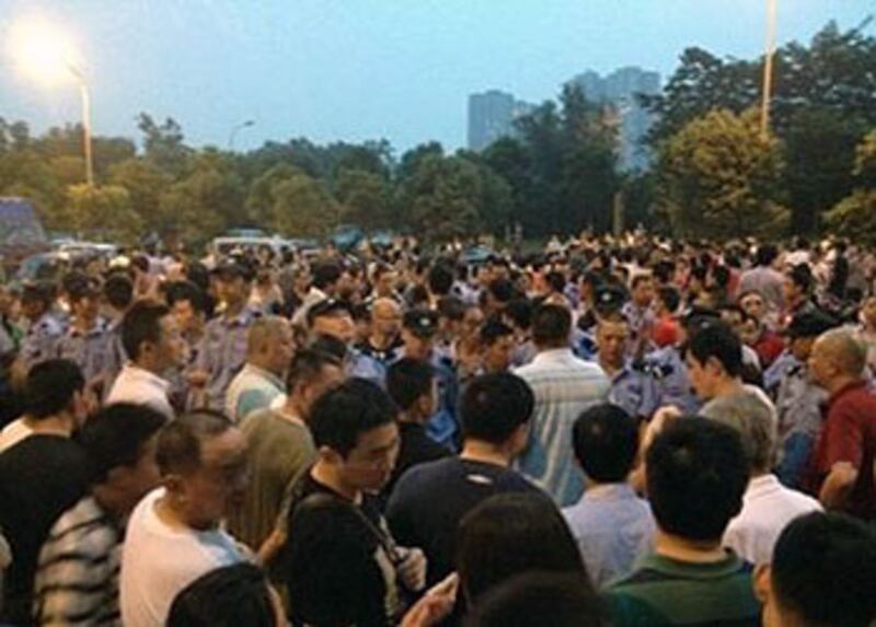 2012年7月18日，成都富麗東方小區業主，不滿連續三十多個小時斷電，走到街上堵路討說法，屋苑保安及城管到場被居民包圍。（業主李先生拍攝）