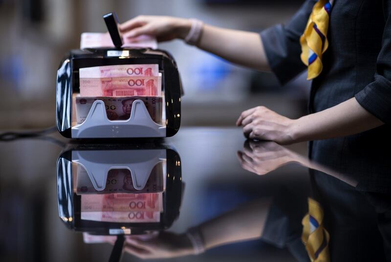 图为银行工作人员在清点人民币。(法新社)
