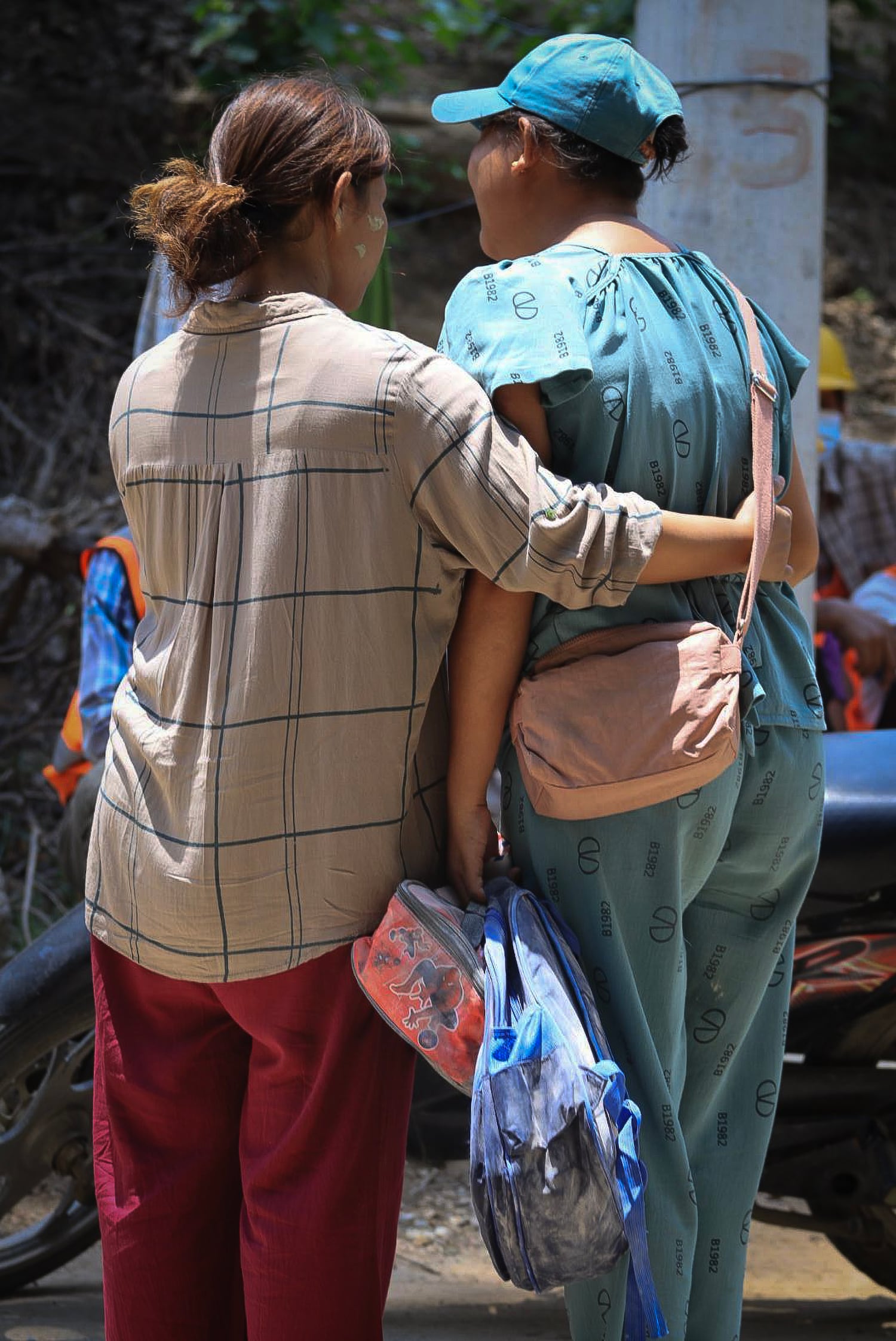 Family members as they collect the belongings of children at a destroyed pre-school in Sagaing city, Myanmar, on April 24, 2025, four weeks after Myanmar's devastating earthquake.