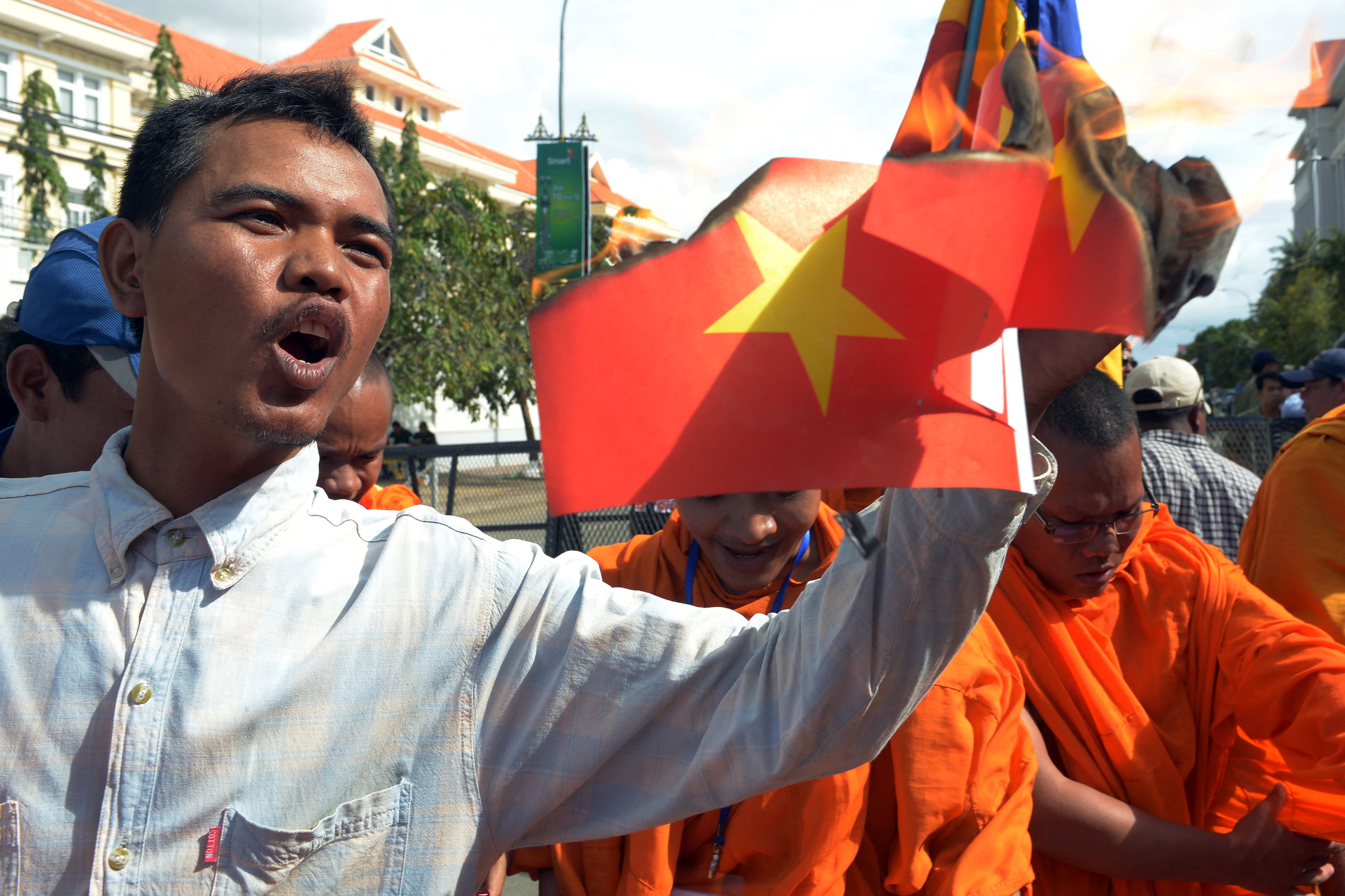 Một người Campuchia đốt cờ Việt Nam trong cuộc biểu tình năm 2014.