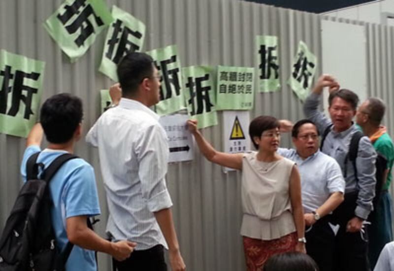 2014年7月18日,十多名民主黨成員,到政府總部的公民廣場外示威,抗議當局在公民廣場外加設三米高圍欄,要求立刻停工。(粵語組林靜報道)