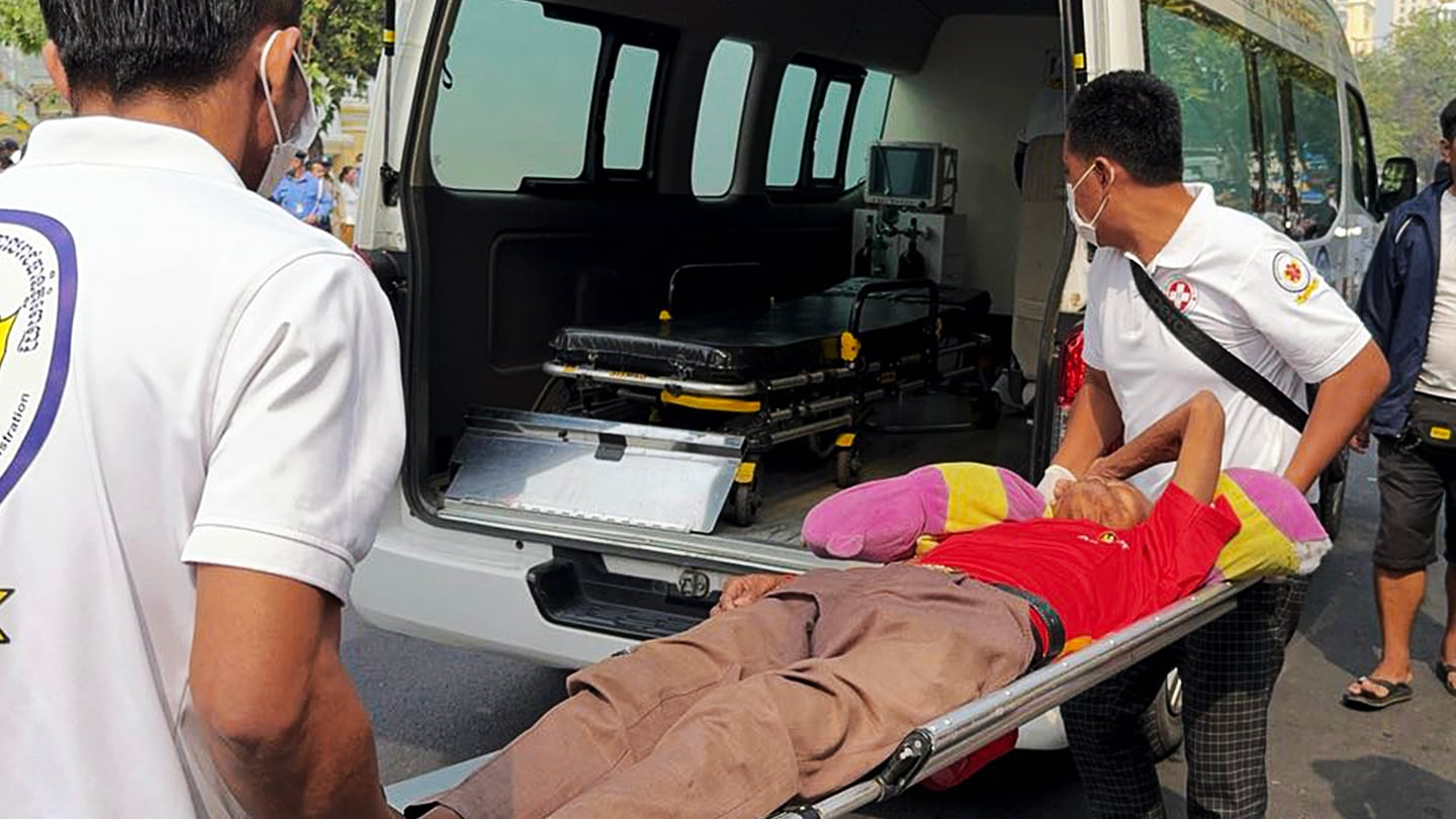 Emergency medical workers carrying a person to an ambulance after a crowd pushed towards the gates of a mansion of Cambodian tycoon Sok Kong to receive red envelopes filled with money, in Phnom Penh, Jan. 23, 2025.