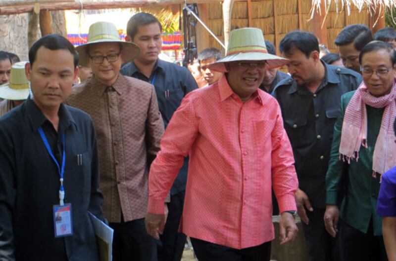 លោក​នាយករដ្ឋមន្ត្រី ហ៊ុន សែន និង​ប្រធាន​គណបក្ស​សង្គ្រោះ​ជាតិ លោក សម រង្ស៊ី (រូប​ពាក់​មួក) ដើរ​ជាមួយ​គ្នា​ក្នុង​ពិធី​បើក​កម្មវិធី​អង្គរ​សង្ក្រាន្ត​នា​ខេត្ត​សៀមរាប កាល​ពី​ព្រឹក​ថ្ងៃ​ទី​១៤ មេសា ឆ្នាំ​២០១៥។