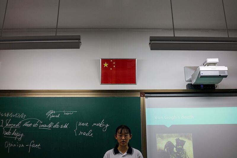 资料图片：2017年9月28日，一名学生站在上海学校教室的中国国旗下面。（法新社）