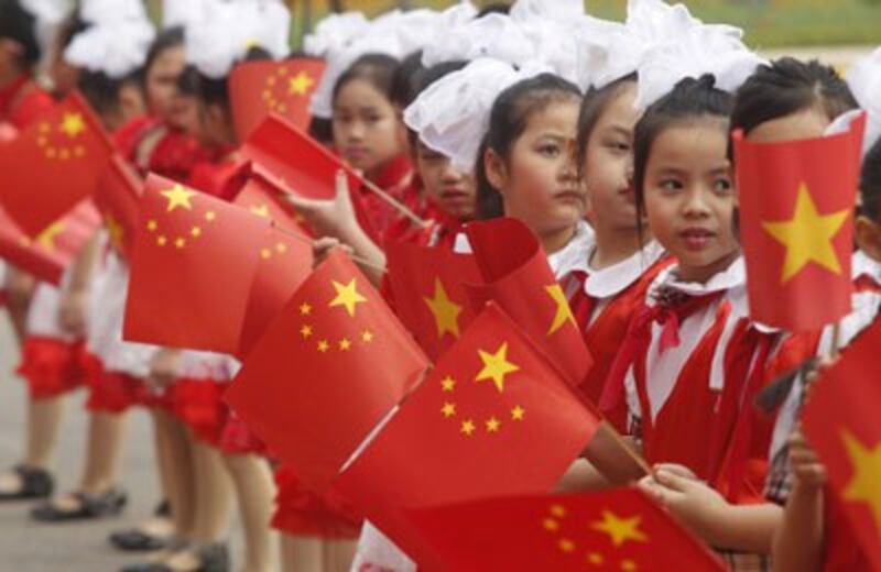 Các em học sinh tiểu học vẫy cờ Trung Quốc đón chủ tịch Trung Quốc Tập Cận Bình tại Hà Nội hôm 21/12/2011. AFP photo