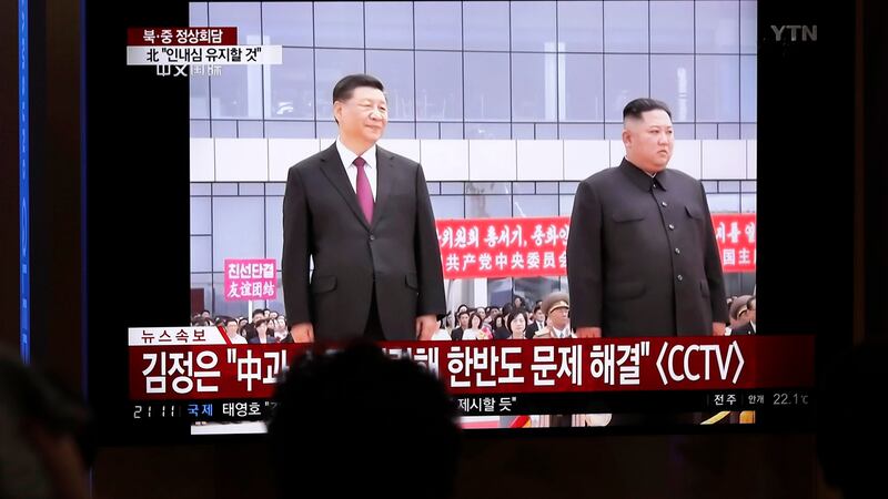 韩国民众在电视上观看金正恩接待习近平访问朝鲜的画面。(美联社)
