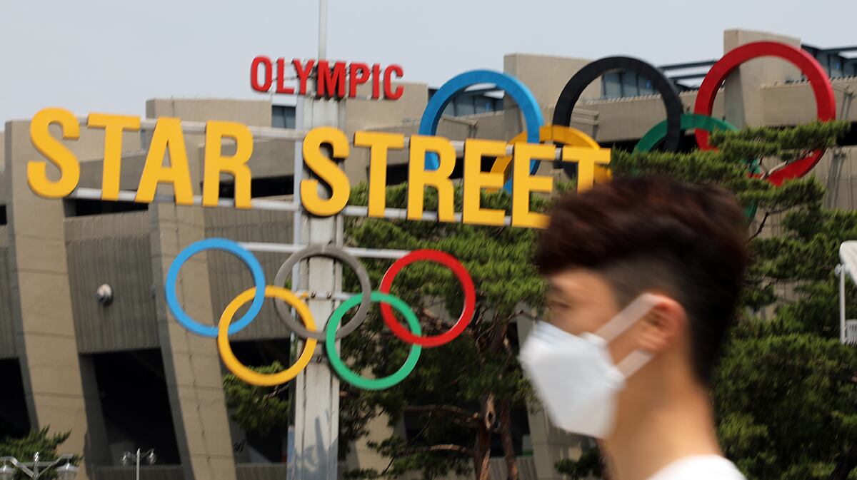 2일 잠실 종합운동장에 설치된 오륜기 모형 앞으로 마스크를 한 시민이 지나가고 있다.