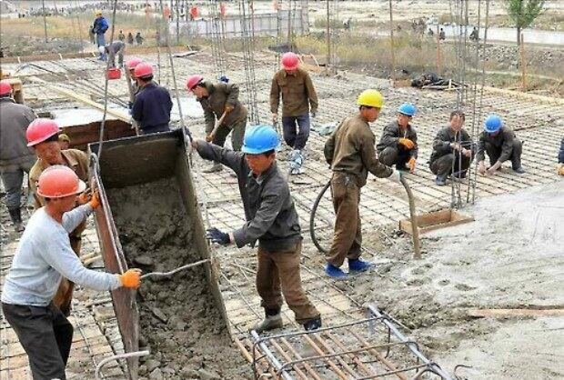 사진은 홍수피해 후 함경북도 경원군 후석지구 '살림집건설전투장'에서 작업하는 노동자들.