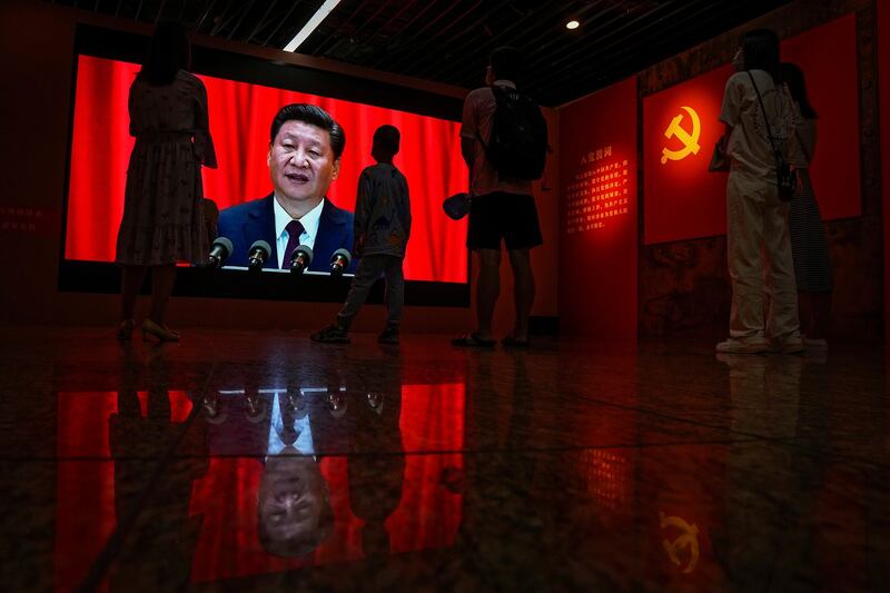 Visitors watch a screen of Chinese President Xi Jinping delivering a speech at an exhibition promoting China's achievement under communist party from 1921 to 2021, in Beijing, June 2021. After the Chinese Communist Party seized power, officials were largely divided into two key categories: those in charge of party governance and those tasked with running the government. Credit: Andy Wong/AP