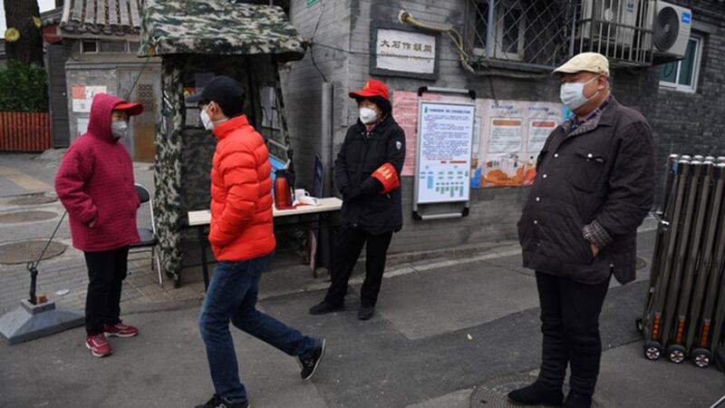 北京有些小区实施封闭管理,几名志愿者在一个胡同口设立检查站。(法新社)