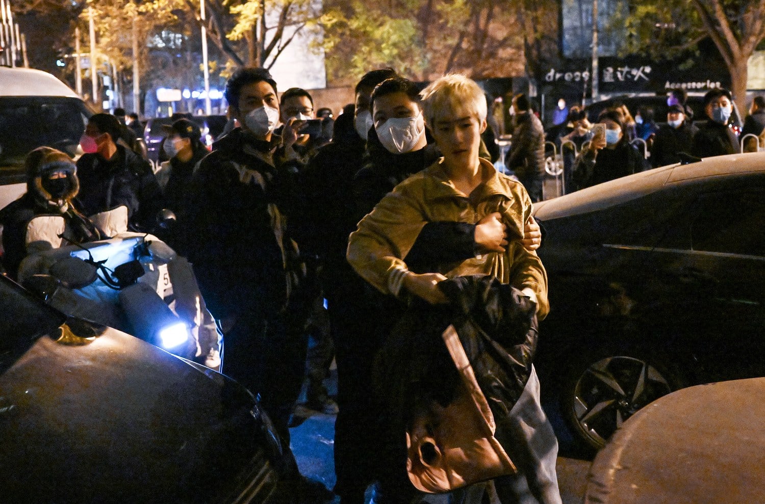 A protester scuffles with police during a rally for the victims of the Urumqi fire as well as a protest against China's harsh COVID-19 restrictions in Beijing on Nov. 28, 2022. Credit: AFP
