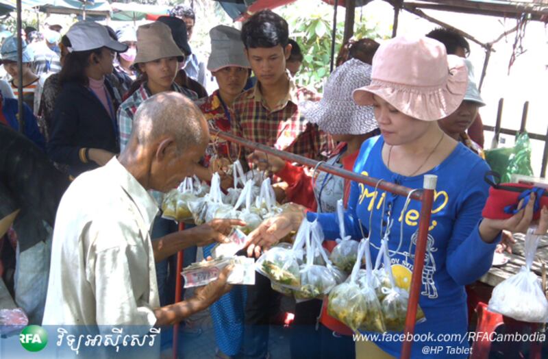 ក្រុមកម្មករចោមទិញម្ហូបអាហារនៅខាងមុខរោងចក្រមួយក្នុងរាជធានីភ្នំពេញ។
