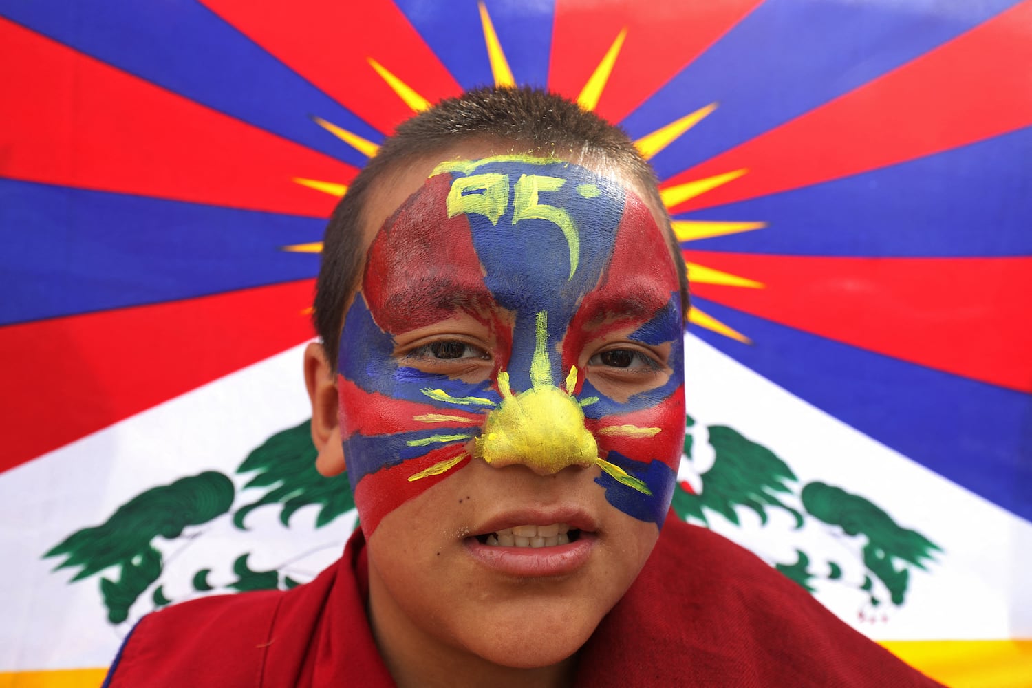 A Tibetan youth with his face painted in the colors of the Tibetan flag attends a peace march during the 65th Tibetan National Uprising Day against the Chinese occupation of Tibet, near Dharamsala, India, on March 10, 2024.