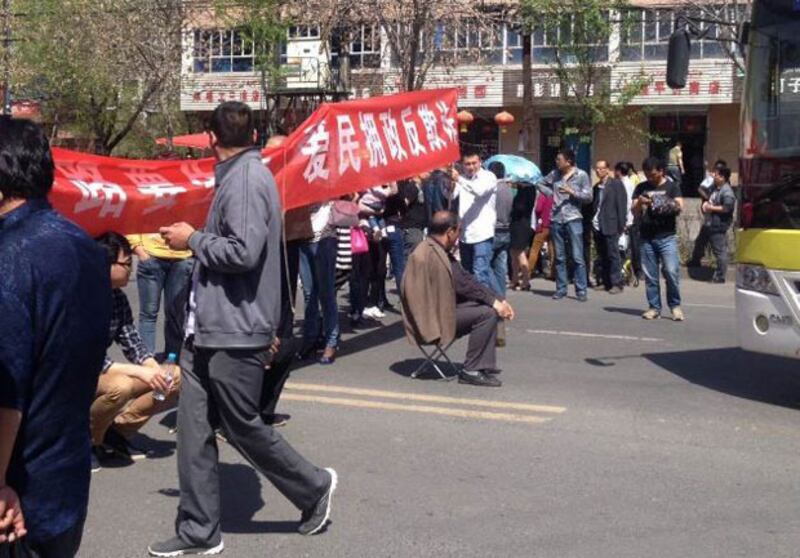 2015年4月23日，新疆烏魯木齊市米東區“華都景盛苑”三百名業主，手持維權橫額，把屋苑門外的馬路堵死，抗議地產開發商突收回小區出入通道用地。（業主攝）