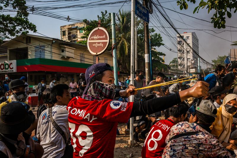 Anti-coup protesters prepare to use slingshots against security forces on March 28, 2021 in Yangon, Myanmar.