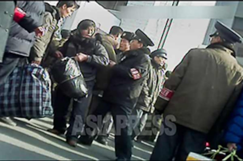 통행증이 없거나 규정 이상의 큰 짐을 가진 사람의 역내 입장을 단속하기 위해 '질서유지대' 완장을 두른 역무원이 역 입구에 배치 돼 있다. 2012년 11월 신의주역. 사진-아시아프레스 제공