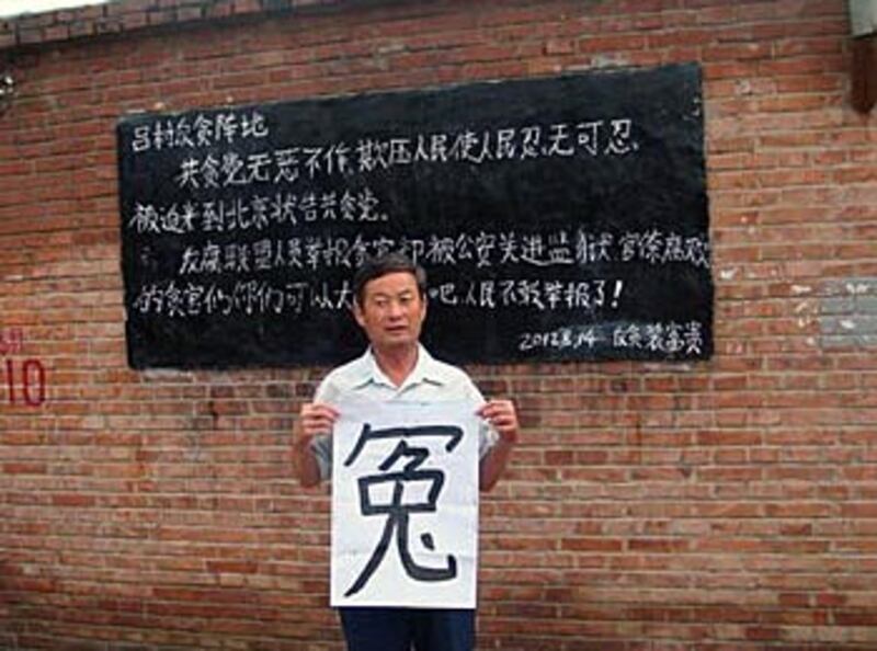 上訪十年先後被勞教三次的河北訪民楊先生，高舉橫額嗚冤。 (相片由訪民程女士提供)