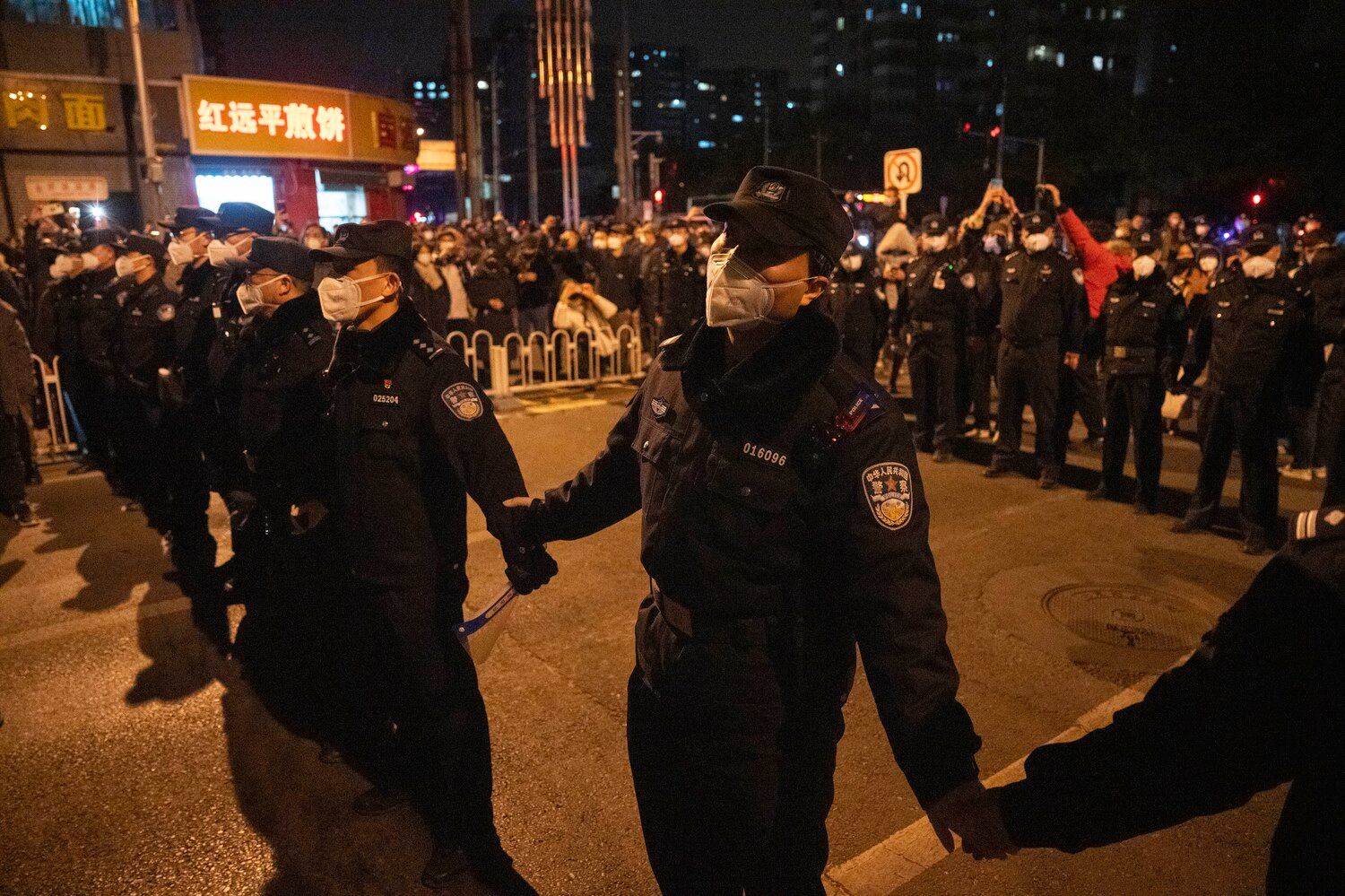 지난 27일 베이징에서 경찰이 코로나 봉쇄에 항의하는 시위대의 행진을 막고 있다.