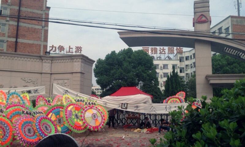 死者家屬在廠外擺放花圈和橫幅，要求還死者一個公道。（圍觀者提供）