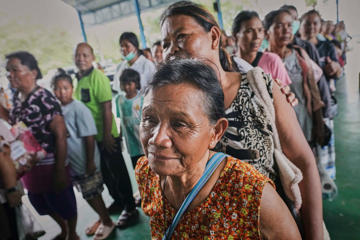 Thai residents who fled homes following clashes between Thai and Cambodian soldiers line up for food at an evacuation center in Surin province, Thailand, July 26, 2025. 