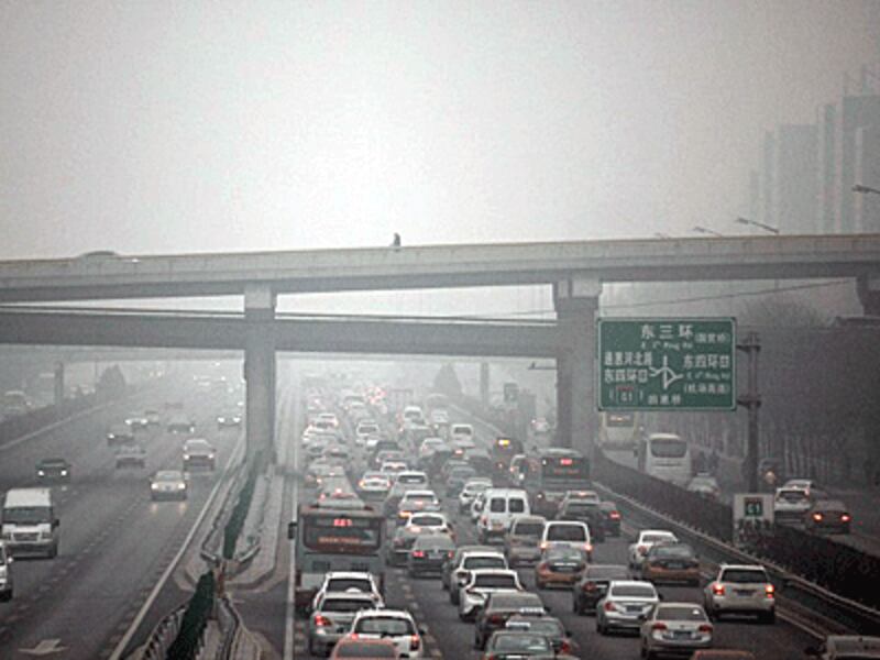A man (top C) walks along an overpass amid heavy smog in Beijing during the Chinese capital's first-ever red alert for air pollution, Dec. 8, 2015.