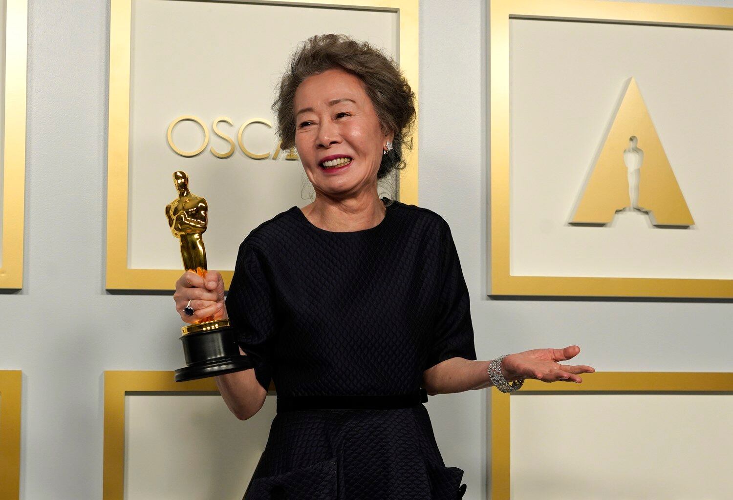 아카데미상 여우 조연상을 받은 윤여정 씨가 기자회견장에서 트로피를 들고 환하게 웃고 있다.