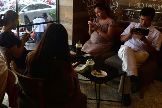 Người dân sử dụng smart phone, iPad để truy cập thông tin trong một quán cà phê ở Hà Nội hôm 23/7/2014.