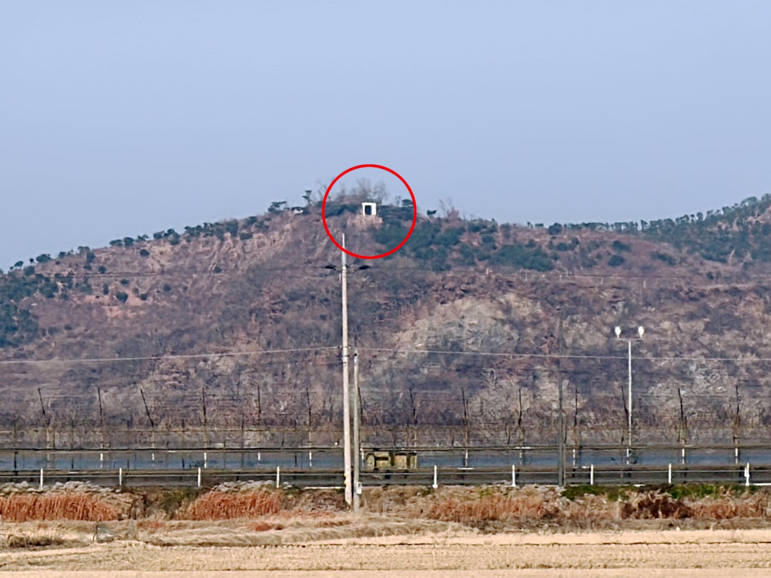 A speaker, the white box inside red circle, sis on top of a mountain in North Korea, and is aimed at residents across the border in South Korea.