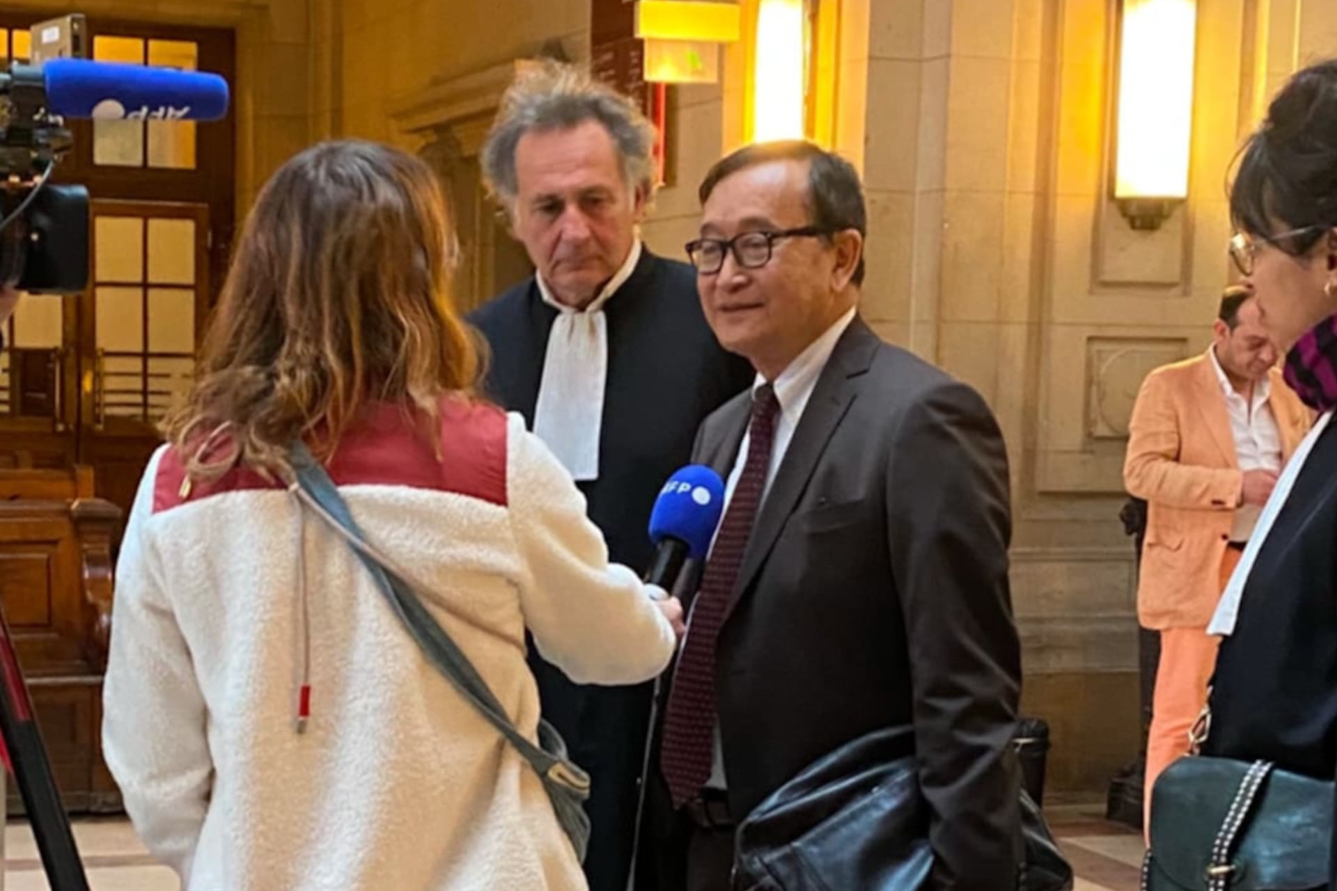 លោក សម រង្ស៉ី (កណ្តាល) និងមេធាវី ផ្តល់បទសម្ភាសដល់អ្នកព័ត៌មាននៃទីភ្នាក់ងារសារព័ត៌មានបារាំង (AFP) ក្នុងអគារតុលាការបារាំង ទីក្រុងប៉ារីស។