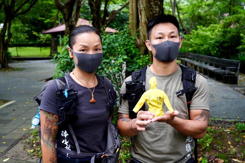 「赴湯杜火」夫婦湯偉雄及杜依蘭，帶同身穿寫上「林鄭殺港　黑警冷血」的黃色雨衣公仔。（淳音 攝）