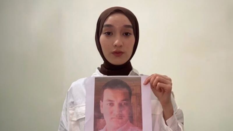 نەفىسە ئوغۇز تاغىسى ئالىم ئابدۇكېرىمنىڭ سۈرىتىنى تۇتۇپ تۇرغان كۆرۈنۈش
