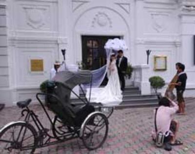 Một đôi vợ chồng đang chụp ảnh cưới tại Hà Nội hôm 26/08/2010. AFP PHOTO.