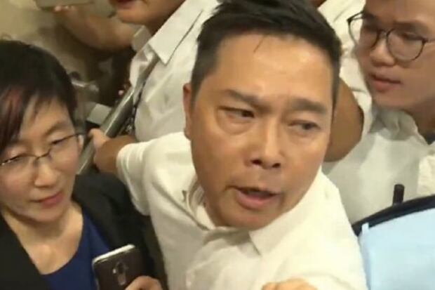 2019年7月11日,油尖旺民政事務專員蔡亮(左)前往區議會開會時,遭示威者包圍。(網上視頻截圖)