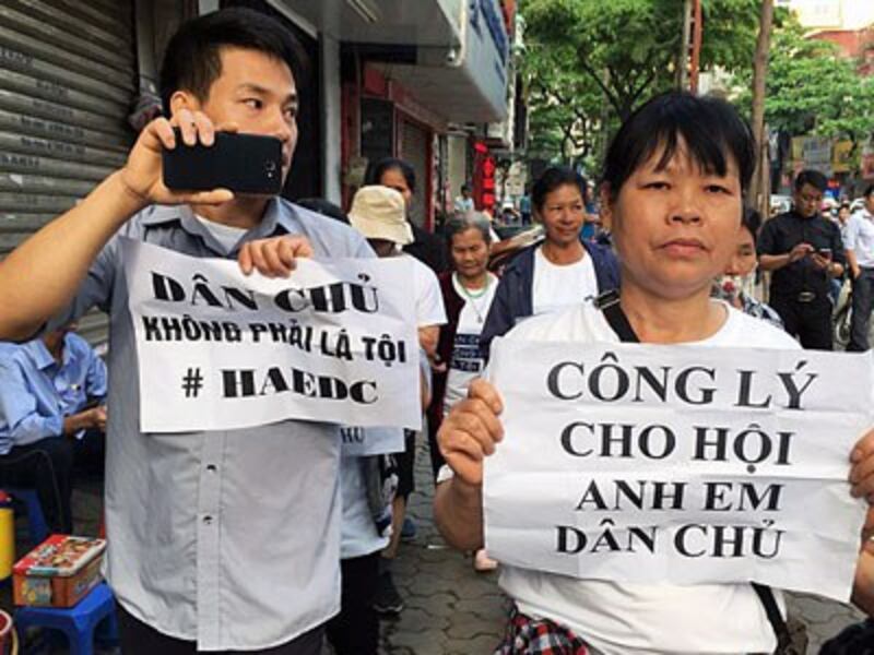Vietnamese protesters display placards as they march towards a courthouse during the trial of a prominent rights lawyer and five other activists in Hanoi, April 5, 2018.
