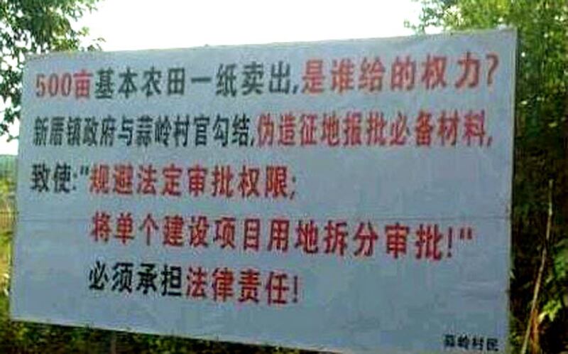 2013年4月,蒜嶺村一片農地遭村委會私賣予開發商建廠,村民於農地上插上維權標語,指責村官的侵權行為。(村民提供)
