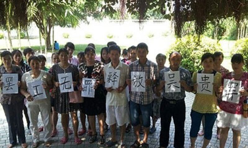 深圳市港資“迪威信”傢俱廠工人代表吳貴軍，被拘留至今逾120日，工友舉牌促請當局盡快將他無罪釋放。（吳貴軍家屬提供） 