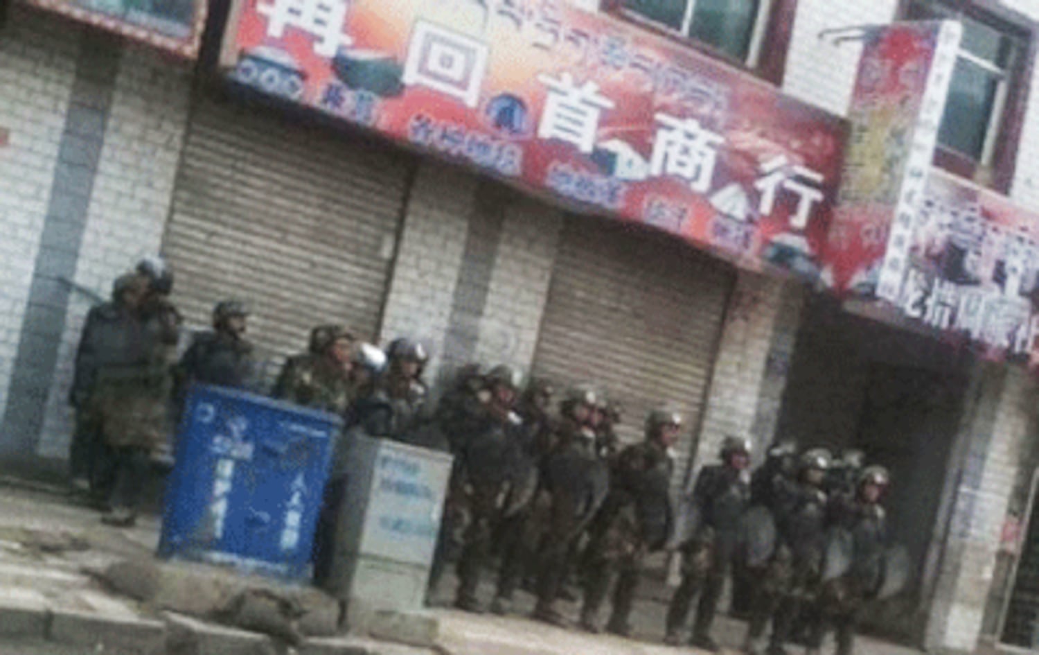 Chinese police waiting along a shophouse near the Rongwo Gonchen Monastery.