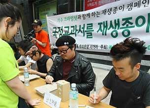 시민들에게 재생종이 공책을 나눠주는 캠페인.