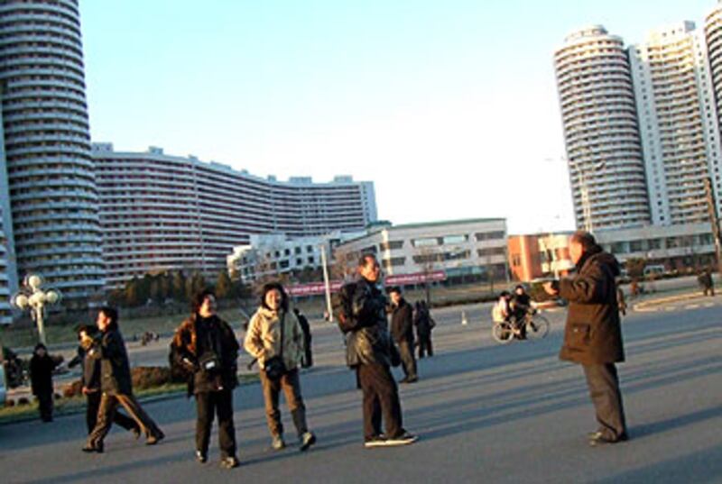 圖片1和11:時值12月,平壤的氣溫寒冷,但在主要街道千里馬大街上,仍然有不少民眾一早出來散步,不過他們對陌生人相當戒備,一般不會主動攀談。記者幸運地問到一名當地市民,他表示,平壤一般百姓現在的月收入大約是7000北韓元,儘管官方指北韓元和人民幣的匯率是16比1,但這個數目實際上只等於人民幣20元左右。他悄悄對記者說,物價是朝鮮的國家機密,官方公佈的匯率只是用來欺騙外國人。不過他指,現在的情況已經比1996年大饑荒時好很多。